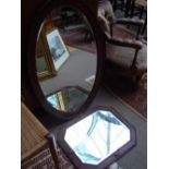 A wooden framed oval wall mirror together with an octagonal wall mirror.