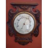 A carved oak aneroid wall barometer, 46 cm high.
