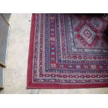 A red ground rug. 291 x 200cm.