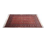 A red ground rug. 188 x 130cm.