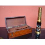 A brass field microscope, with mirror, in original case with two spare lenses.