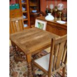 An oak drawleaf table on barleytwist legs, together with two oak chairs.