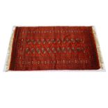 A red ground rug. 168 x 96cm.