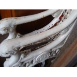 A wooden seated and backed white painted cast iron framed bench with lions heads, bearing the