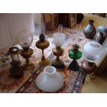 Six Victorian and later oil table lamps with glass, copper and brass reservoirs, in varying