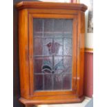 A corner cabinet with stained glass door.