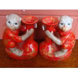 Two Oriental style ceramic candle holders in the form of monkeys.