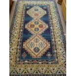 A blue and green ground rug (fringing off in places). 224 x 118cm.