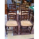 Four oak ladderback chairs, with rush seats.