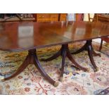 A large reproduction mahogany extending twin pedestal dining table, with two extra leaves.