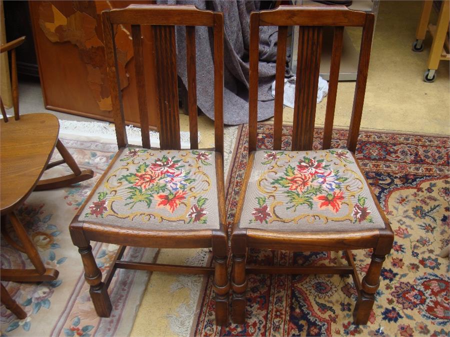 A pair of mahogany dining chairs with drop in embroidered seats.