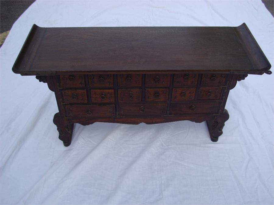 A Korean apothecary cabinet / alter coffer.  The rectangular top with rising ends above two rows