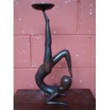 A bronze candle holder in the form of a dancer.