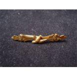 A 9ct bar brooch with floral decoration and a swallow, possibly H/M (H&M) makers.