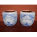A pair of Japanese jardinieres, decorated with Mt Fuji scenes with silhouetted trees, blue and
