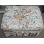 An Ottoman, with floral upholstery, on four plasti