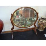 An oval dressing table mirror.