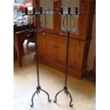 Two wrought iron three branch standing candelabras.