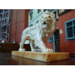 A Continental porcelain model lion, on marble base, 27cm long.