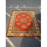 A Chinese style rug, red ground with floral border