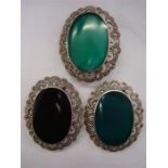 Three brooches of a similar style, two jade and marked 925 and one onyx marked 925. Three brooches