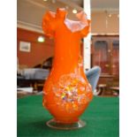 An orange frilly topped vase, with rigaree applied flowers in the style of Stevens and Williams.