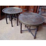 Two brass circular tables, on folding legs, one wi