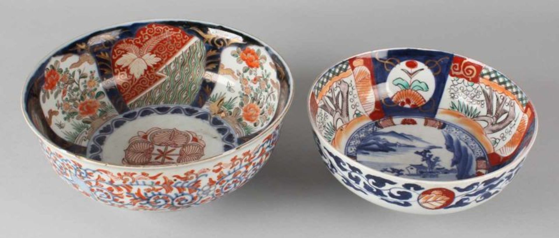 Two 19th century Imari porcelain bowls with landscape and / or floral decorations. (Larger bowl