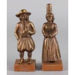 Two antique bronze figures in costume on wooden basement. Around 1920 - 1930. Size: 13 - 14 cm. In