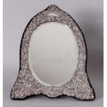 Oval mirror with facet edge provided with a silver edged border with curls, palmets, flowers and a