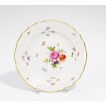 TELLER MIT BLUMENDEKOR. Meissen. Porzellan, farbig und gold staffiert. ø 24 cm. Schwertermarke,