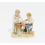 AMORETTEN WURST MACHEND. Meissen. Vor 1924. Porzellan, farbig und gold staffiert. H.11,5 cm.