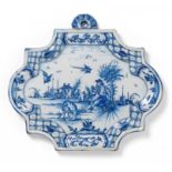 PLAKETTE MIT RASTENDEM BAUER VOR LANDSCHAFT. Delft. 18. Jh. Beiger Scherben mit lichtblauer Glasur