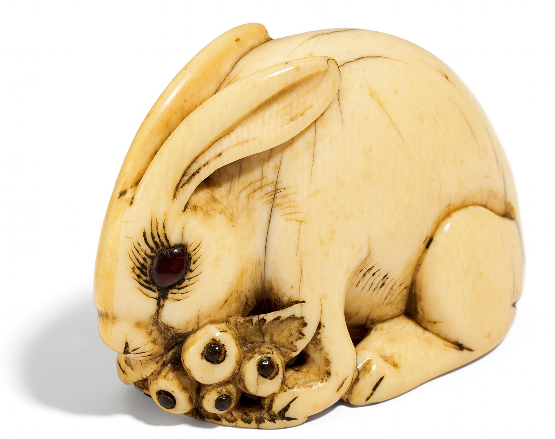 NETSUKE: HASE MIT BIWA-FRÜCHTEN. Japan. Edo-Zeit. 19. Jh. Elfenbein, fein geschnitzt und poliert,