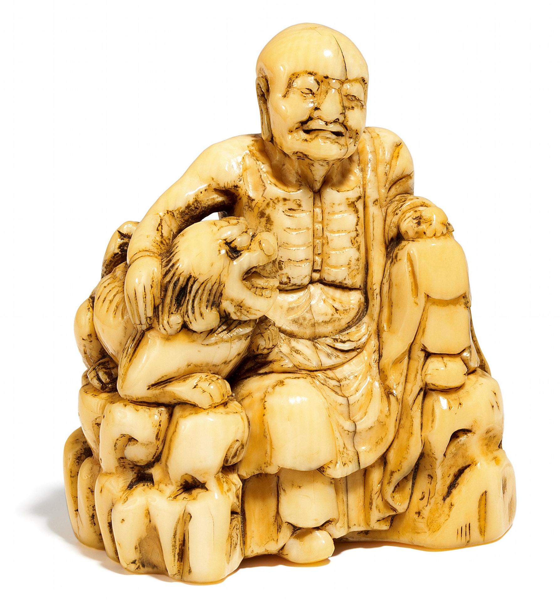 NETSUKE: RAKAN SHUBAKA SONJA. Japan. Edo-Zeit. Elfenbein. Der Rakan sitzt auf einem zerklüfteten