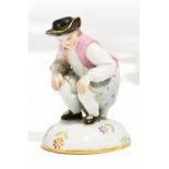 MINIATURFIGUR "DUKATENSCHEISSER". Meissen. 19. Jh. Porzellan, farbig und gold staffiert. Höhe 5cm.