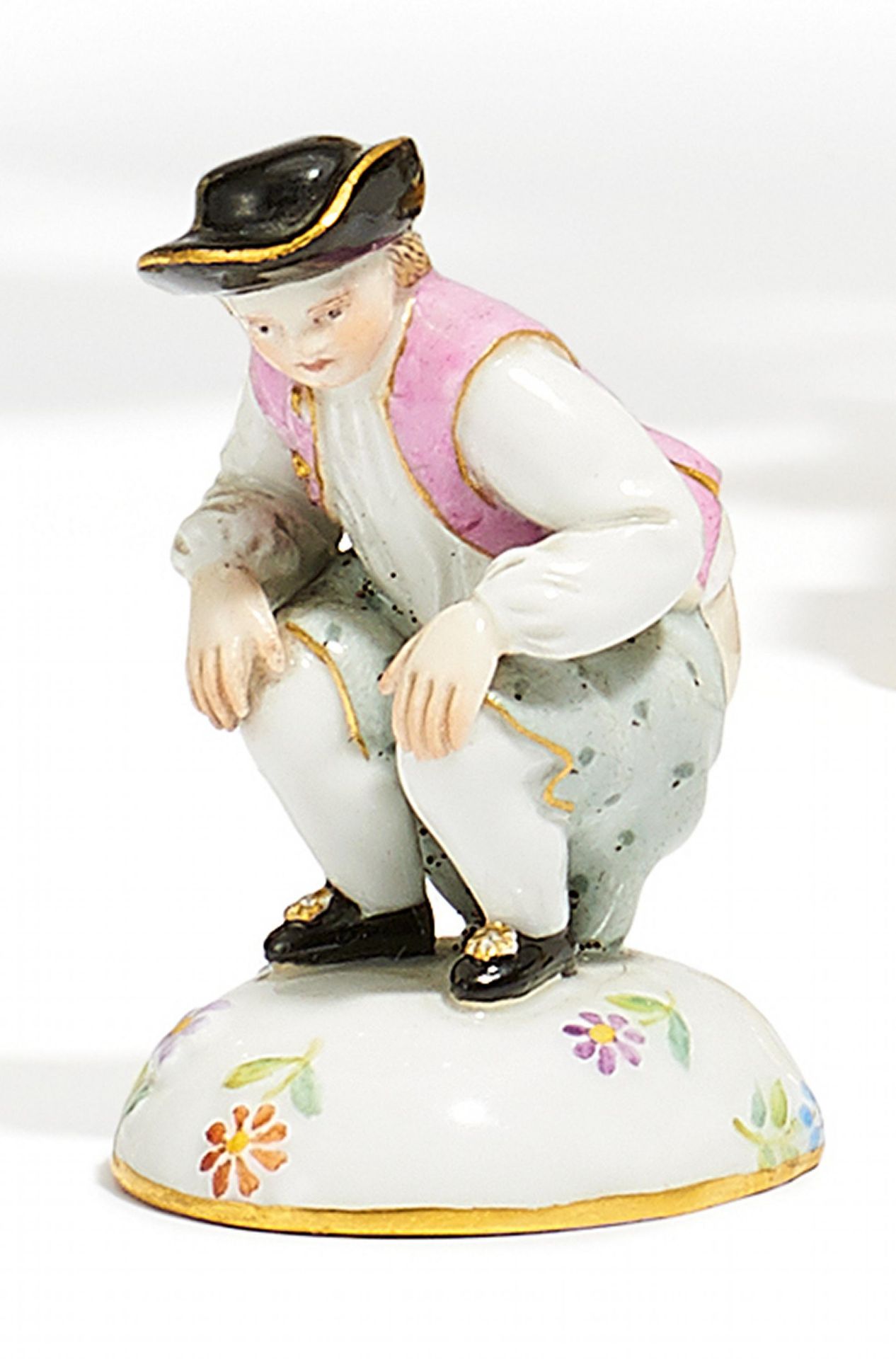 MINIATURFIGUR "DUKATENSCHEISSER". Meissen. 19. Jh. Porzellan, farbig und gold staffiert. Höhe 5cm.