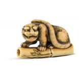 NETSUKE: TIGER AUF BAMBUS. Japan. Edo-Zeit. Spätes 18. Jh. Kyôto-Schule. Elfenbein mit goldgelber