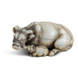 NETSUKE: LIEGENDE KUH MIT KALB. Japan. Edo-Zeit. 18. Jh. Prächtige, wohlgenährte Kuh, liegend mit