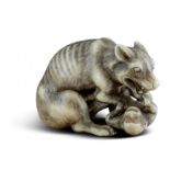 NETSUKE: WOLF MIT AFFE. Japan. Edo-Zeit. 2. H. 18. Jh. Sitzender, magerer Wolf mit