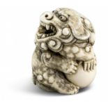 NETSUKE: SHISHI MIT BALL. Japan. Edo-Zeit. 19. Jh. Kyûshû. Mitsuhara zugeschrieben. Elfenbein mit