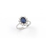 18 krt. witgouden entourage ring met blauwe saffier 18 krt. witgouden entourage ring bezet met 1