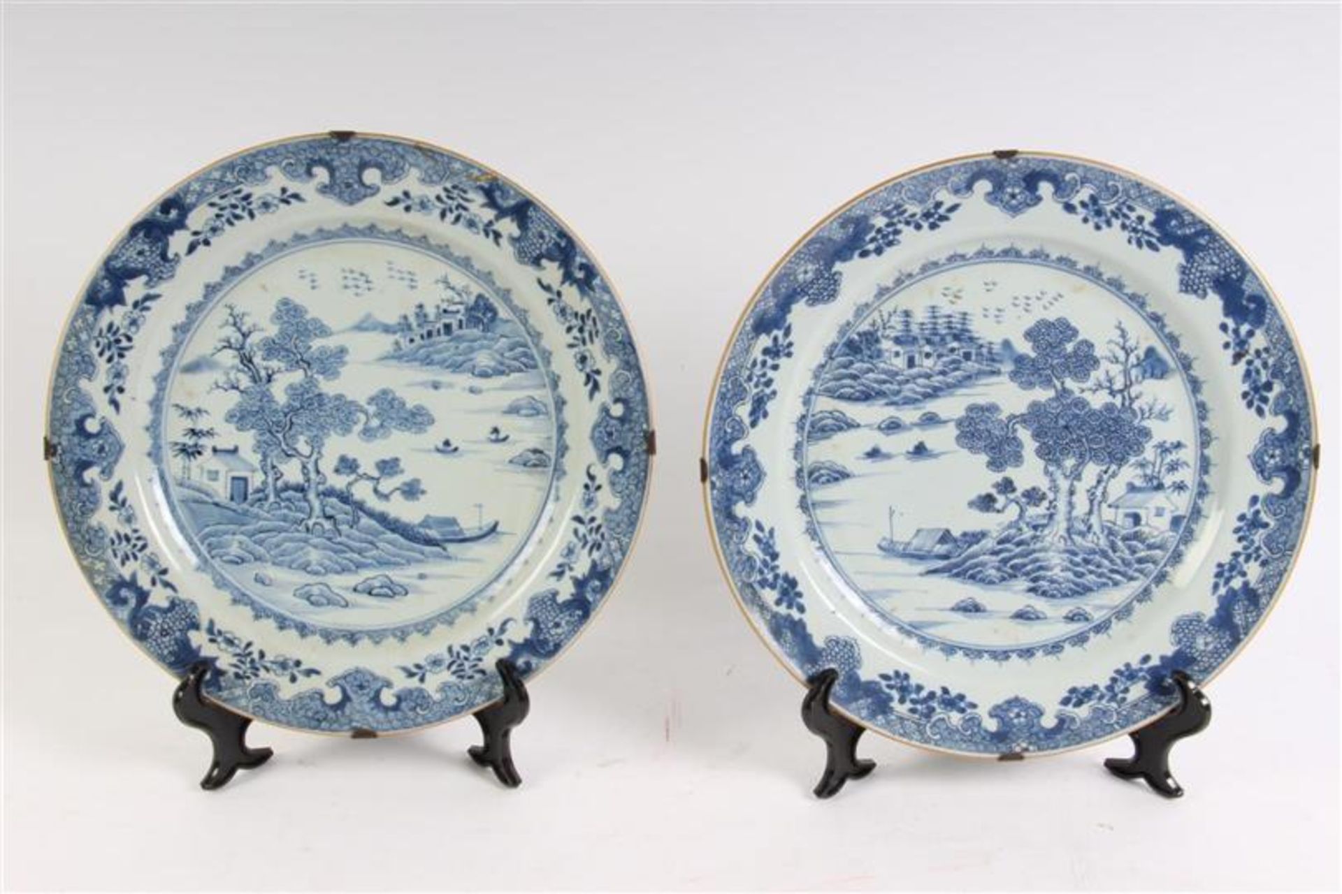 Twee Chinees porseleinen schotels met rivierlandschapdecor, 18e eeuw, één geplakt. D: 30.5 cm.