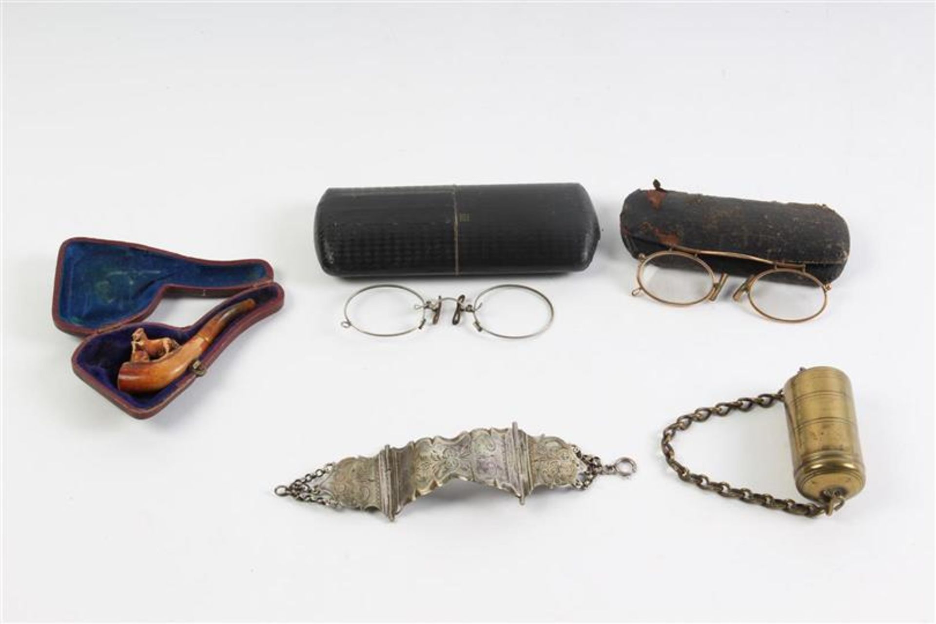 Twee brillen in foudraal, dito pijp, tondeldoos en een armband vermaakt van een bijbelslot.