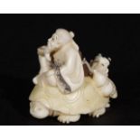 Ivory netsuke, Man with a child on a turtle, signed, l. 4 cm. 27.00 % buyer's premium on the hammer