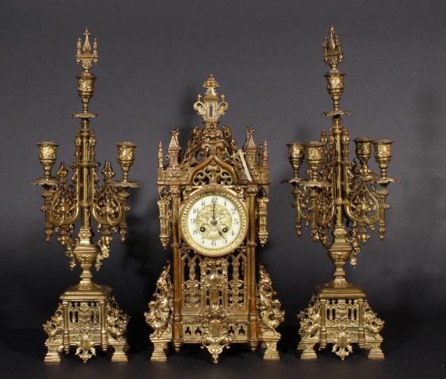 French bronze garniture: clock with two candlesticks, incl. key, one candlestick is broken (3x) 27.