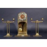 J.C. Stoffels, yellow copper clock with enameled numerals and two yellow copper candlesticks, all