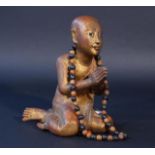 Wooden Tibetan monk with prayer necklace, 20th century, partly gilt, h. 29 cm. 27.00 % buyer's