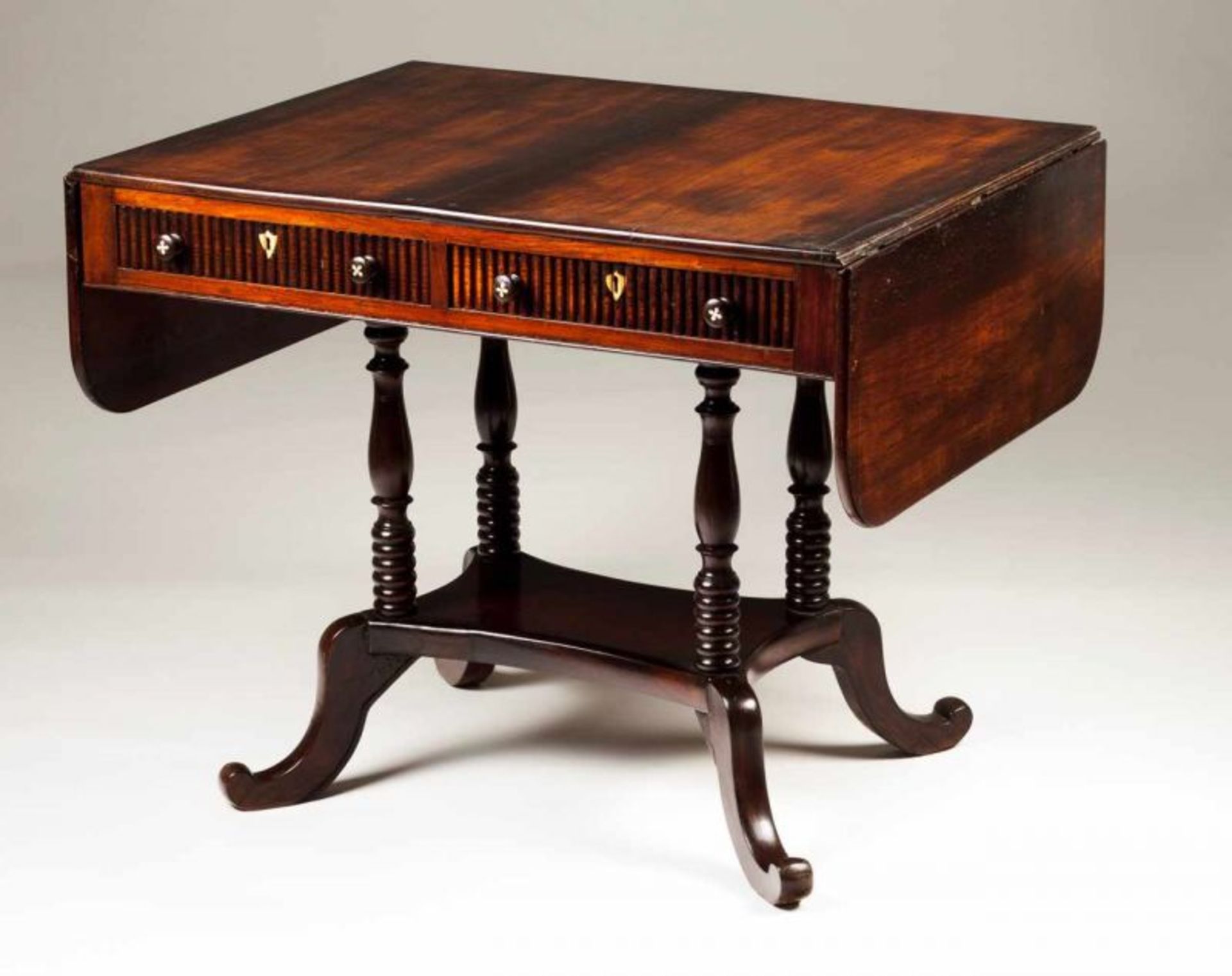 A George III sofa-table Rosewood Two drawers Foot with turned columns England, 19th century 74x92,