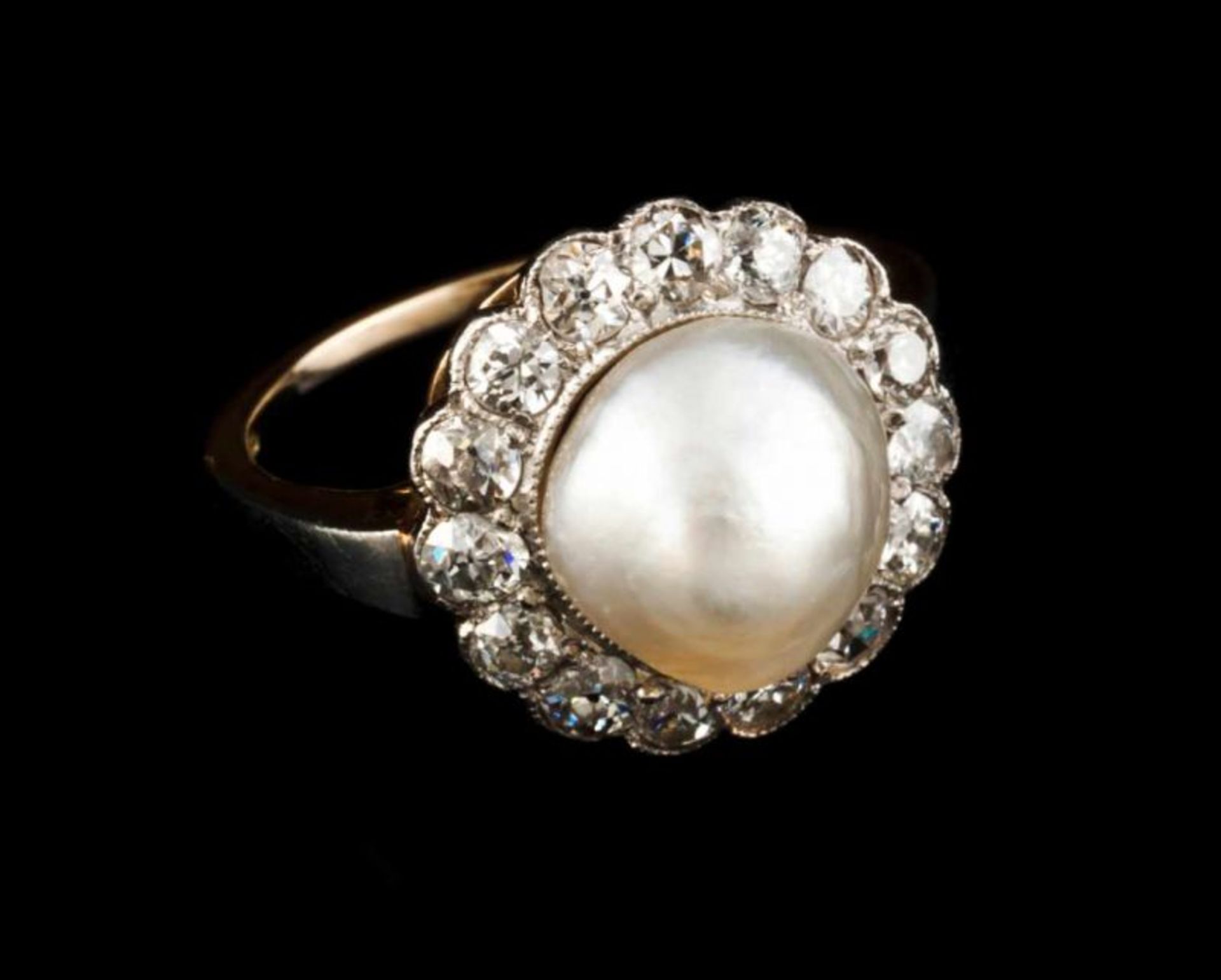 A ring 18kt gold and platinum set with one baroque pearl and 15 old brilliant cut diamonds (ca. 0,